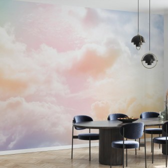 Imaginea de fundal Clouds in the Sky, prezintă nori albi pufoși pe un fundal colorat pastelat, care se transformă de la roz la galben, în timp ce lumina soarelui se reflectă ușor prin ei.