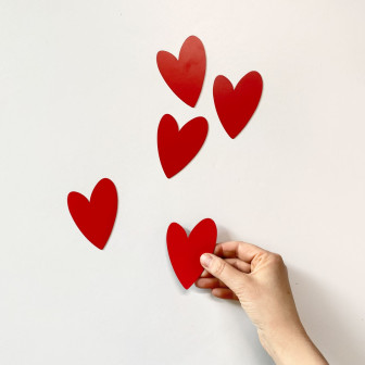Magneți roșii în formă de inimă pe un frigider alb