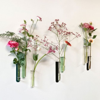 Vază magnetică sub formă de eprubetă, neagră, pe perete cu flori