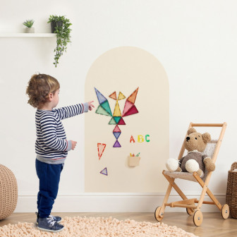 Băiețel folosind o tablă magnetică autoadezivă în formă de arcadă pentru a crea forme cu piese magnetice