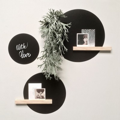Set stickere magnetice rotunde negre pe perete alb, cu diverse obiecte decorative